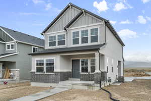 Craftsman inspired home with stucco siding, a mountain view, cooling unit, and board and batten siding