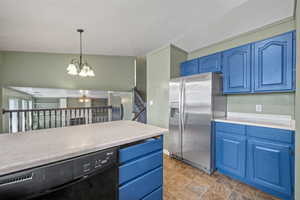 Kitchen with black dishwasher, stainless steel refrigerator with ice dispenser, and blue cabinets