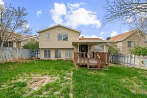 Back of house featuring a fenced backyard, a yard, and a deck