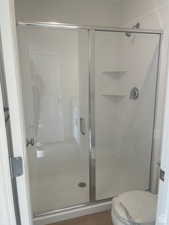 Full bathroom with a shower stall and toilet