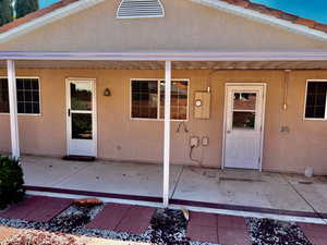 Entrance to property featuring a patio and stucco siding
