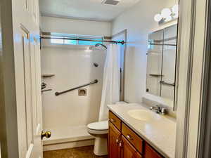 Bathroom featuring curtained shower, vanity, and tile patterned floors