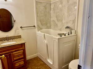 Full bath with tile patterned floors, a bathtub, toilet, baseboards, and vanity