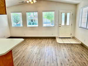 Unfurnished dining area with light wood finished floors, vaulted ceiling, visible vents, and a wealth of natural light