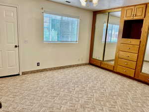 Unfurnished bedroom featuring light carpet and a closet
