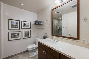 Bathroom with a tile shower and tile patterned flooring