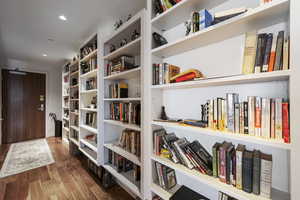 Interior space with wood finished floors, build in bookcases and recessed lighting