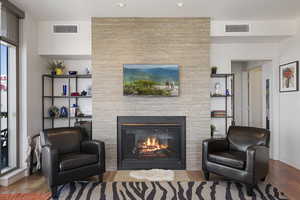 Living area with a fireplace, wood finished floors, and recessed lighting
