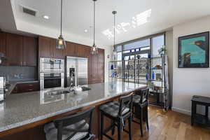 Kitchen featuring a sink, a breakfast bar area, light wood-type flooring, appliances with stainless steel finishes.