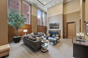 Carpeted Social Room with a fireplace, wooden walls, a towering ceiling, and recessed lighting
