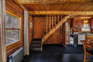 Interior space featuring rustic walls, wood ceiling, and beamed ceiling