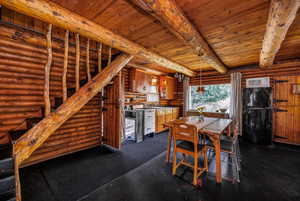 Dining area featuring beamed ceiling, log walls, and wooden ceiling