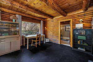 Home office featuring wood ceiling, beam ceiling, rustic walls, and radiator