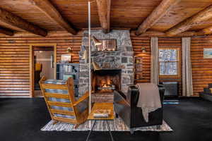 Living room featuring beam ceiling, wooden ceiling, and a fireplace