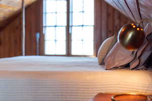 Carpeted bedroom featuring vaulted ceiling and multiple windows
