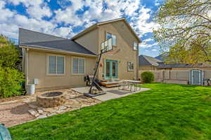Back of house with a patio area, a storage shed, an outdoor fire pit, french doors, and stucco siding