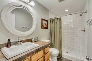 Bathroom featuring vanity, a tile shower, toilet, visible vents, and recessed lighting