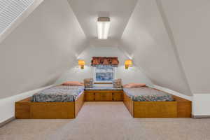 Bedroom featuring light carpet and vaulted ceiling