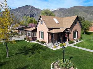 Exterior space featuring fence, a shingled roof, brick siding, and a mountain view