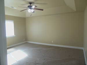 Master Bedroom with treyed ceiling and paddle fan.