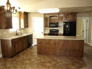 Large kitchen with a center island, granite counter tops, corner pantry, an open shelf over the microwave, extra deep double bay sink, black appliances and oil rubbed bronze plumbing fixtures.