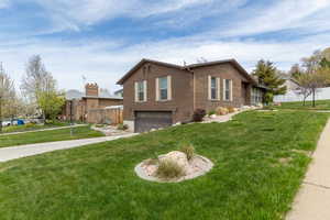 View of side of property featuring a 2 car garage,  driveway, and yard