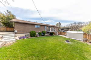 Rear view of house featuring stairway, a fenced backyard,