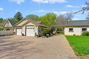 East side view of Craftsman-style home with 3-tone painted brick / cedar shake shingles, (1 of 2) 2-car garages and RV parking