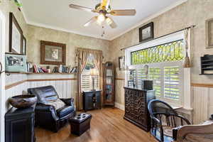 Front room/office with hardwood floors, ceiling fan, leaded glass transom window and crown molding
