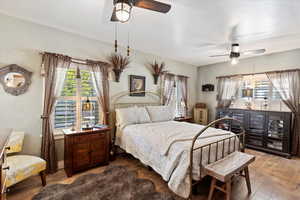 Large primary bedroom featuring hardwood flooring, 2 ceiling fans, and lots of natural light,  plantation shutters