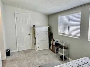 Carpeted bedroom with baseboards and a textured ceiling