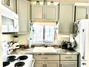 Kitchen featuring white appliances and a sink