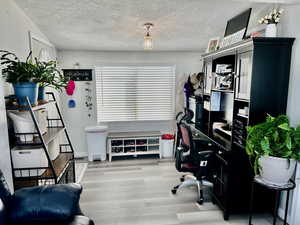 Office area featuring wood finished floors and a textured ceiling