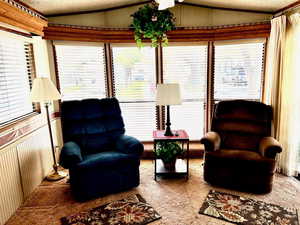 Sitting room with vaulted ceiling, a textured ceiling, and crown molding