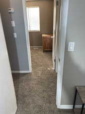 Corridor with baseboards and carpet flooring