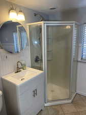 Full bath featuring a shower stall, tile patterned floors, and vanity