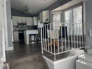 Interior space with stainless steel appliances, vaulted ceiling, plenty of natural light, and ceiling fan