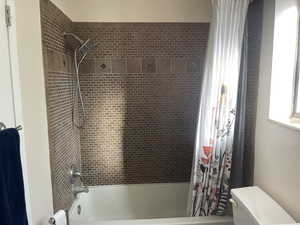 Bathroom featuring shower / tub combo and toilet