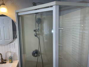 Bathroom with a stall shower and a sink