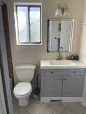 Full bathroom with tile patterned floors, vanity, and toilet