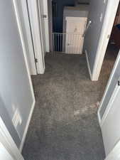 Hall with carpet floors and an upstairs landing
