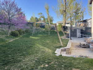 View of yard with a storage shed, a playground, fence, a patio area, and an outdoor structure