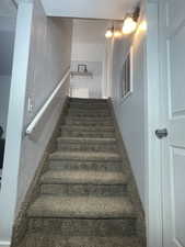 Staircase to basement featuring a textured wall