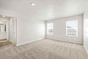 Empty room with light colored carpet, baseboards, and recessed lighting