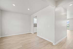 Spare room featuring light wood finished floors, recessed lighting, and baseboards
