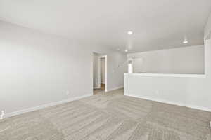 Carpeted empty room with recessed lighting and baseboards