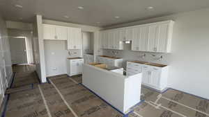 Kitchen featuring a kitchen island and white cabinetry