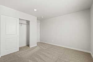 Unfurnished bedroom with carpet floors, a closet, baseboards, and recessed lighting