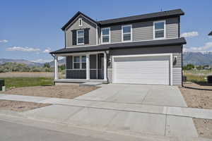 View of front of property with a mountain view, concrete driveway, a garage, a porch, and central AC