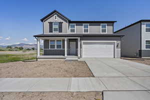 Traditional-style home featuring board and batten siding, covered porch, concrete driveway, a garage, and a mountain view